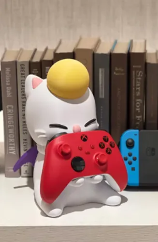 Moogle figure holding an Xbox controller on a shelf